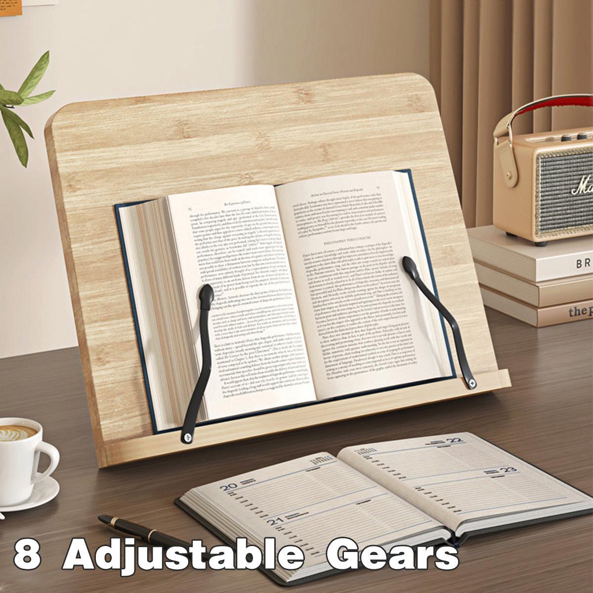 Wooden book stand holding an open book on a desk with a cup of coffee and planner.