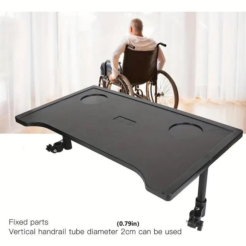 Black adjustable table with wheels in front of a person in a wheelchair, with text about fixed parts and vertical handrail tube diameter.