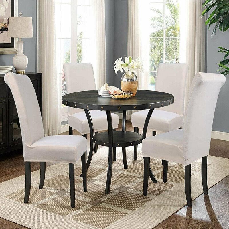 Dining room with a black round table and white chairs.