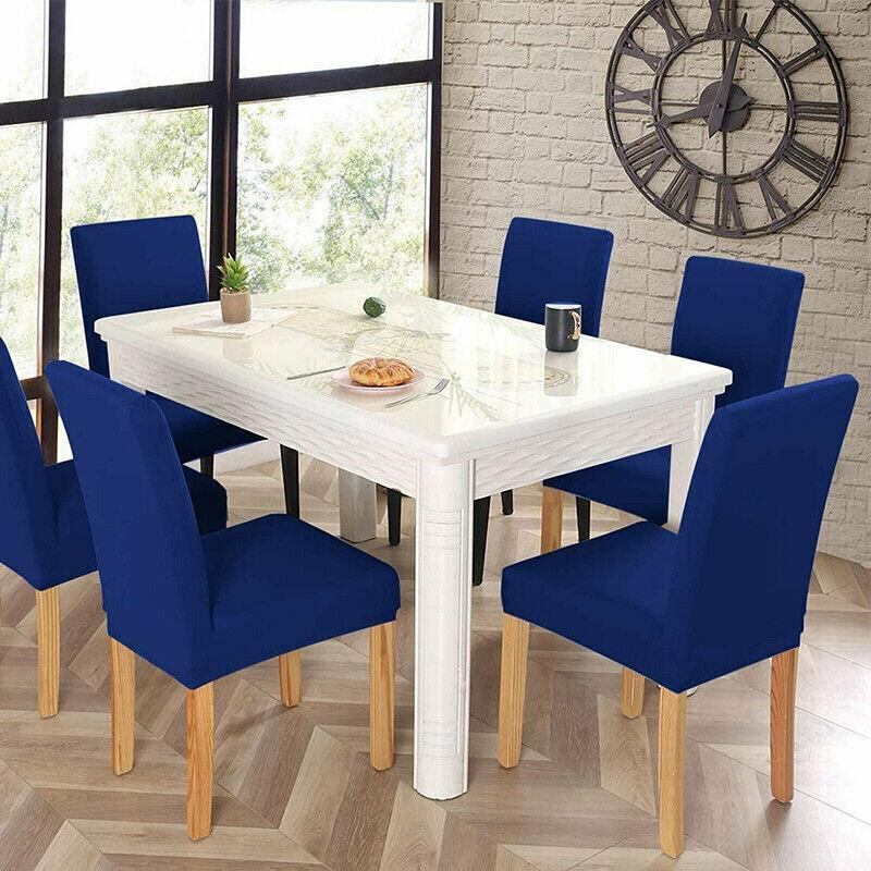 Dining room with a white table and blue chairs, featuring a clock on the wall.