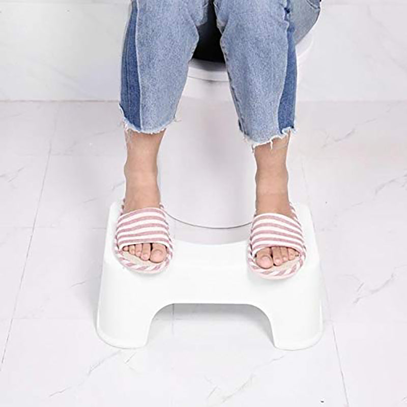 Person using a step stool on a white floor