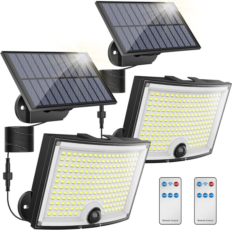 Set of solar flood lights with remote controls on a white background