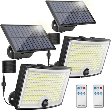 Set of solar flood lights with remote controls on a white background