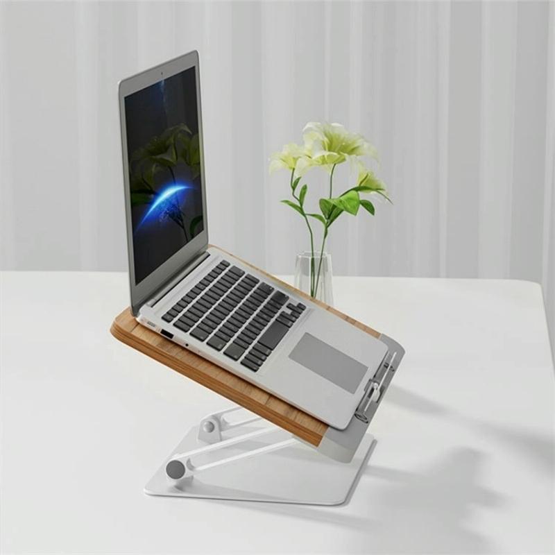 Laptop on a wooden stand with a flower vase on a white surface