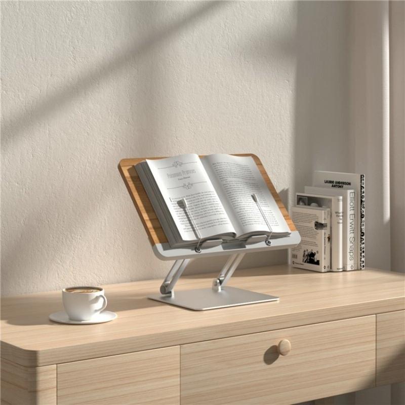 Wooden book stand with an open book on a wooden desk, next to a cup of coffee.