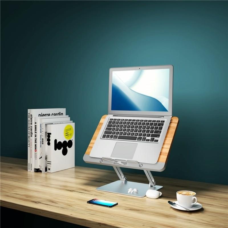 Laptop on a wooden stand with a blue screen on a wooden desk against a dark teal wall.