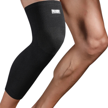 Black knee brace on a person's leg with a white background
