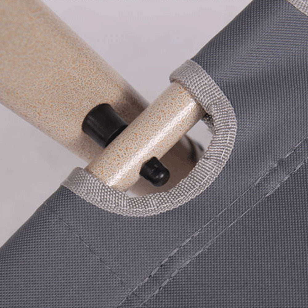 Close-up of a gray bag with a beige handle and black plastic clips on a light gray background.