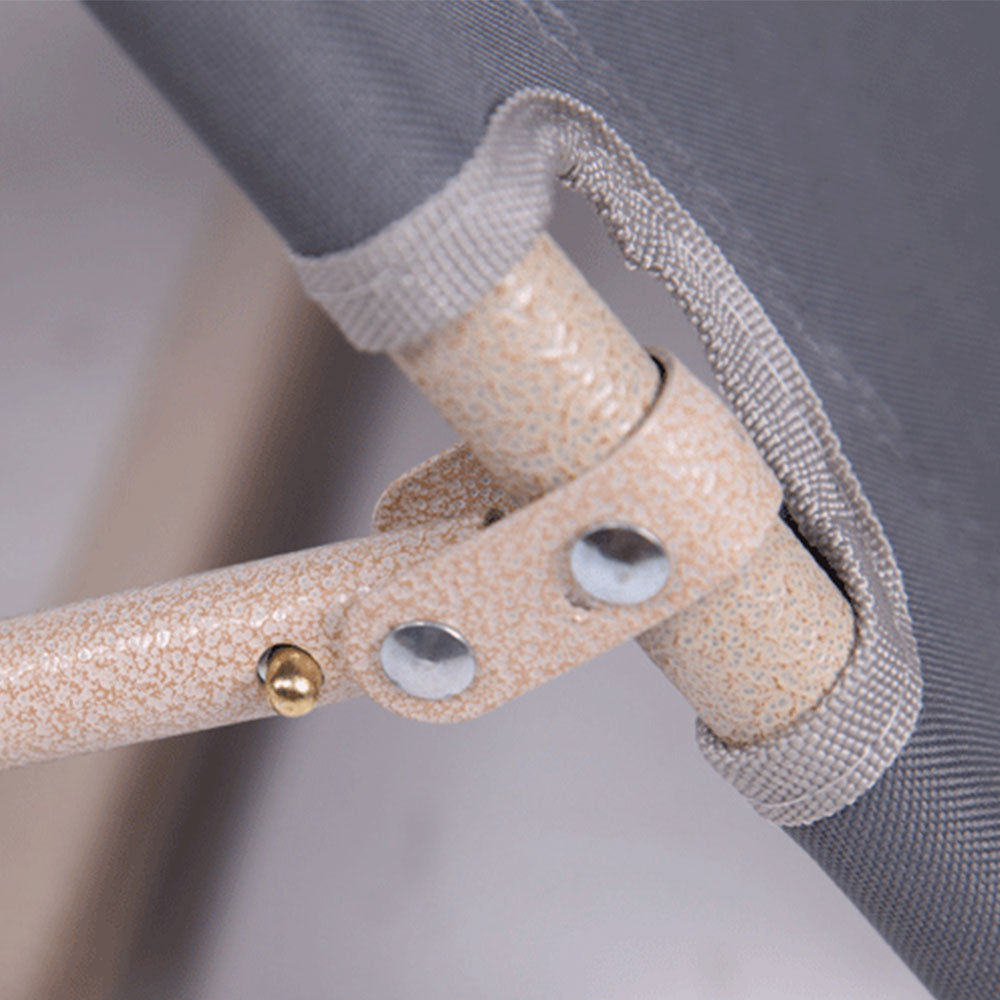 Close-up of a beige crutch with textured handle and metal buttons on a blurred background