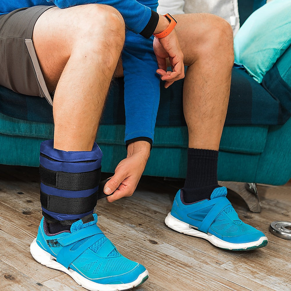 Person wearing blue athletic shoes and a blue cast on a couch.