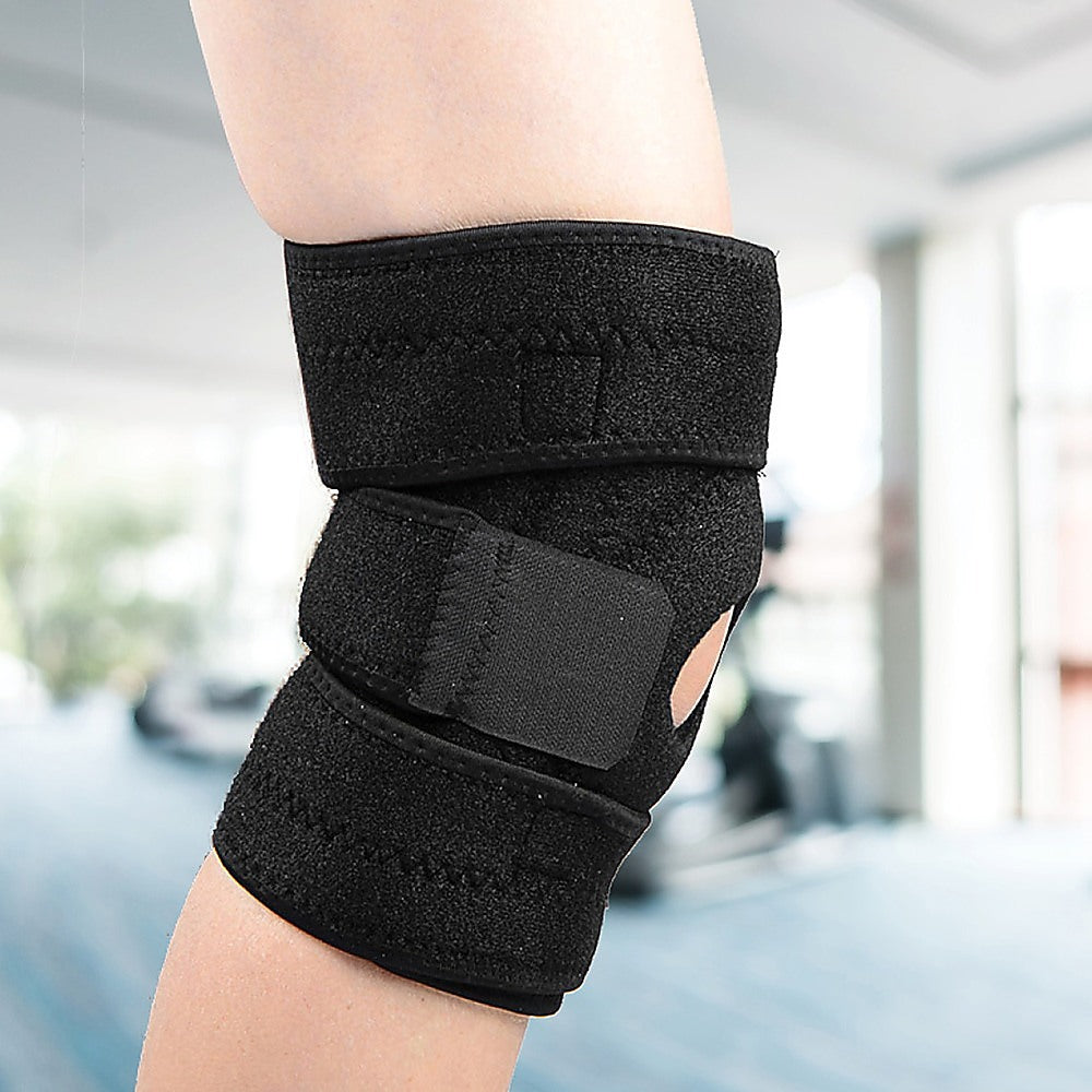 Black knee brace on a person's knee with a blurred background