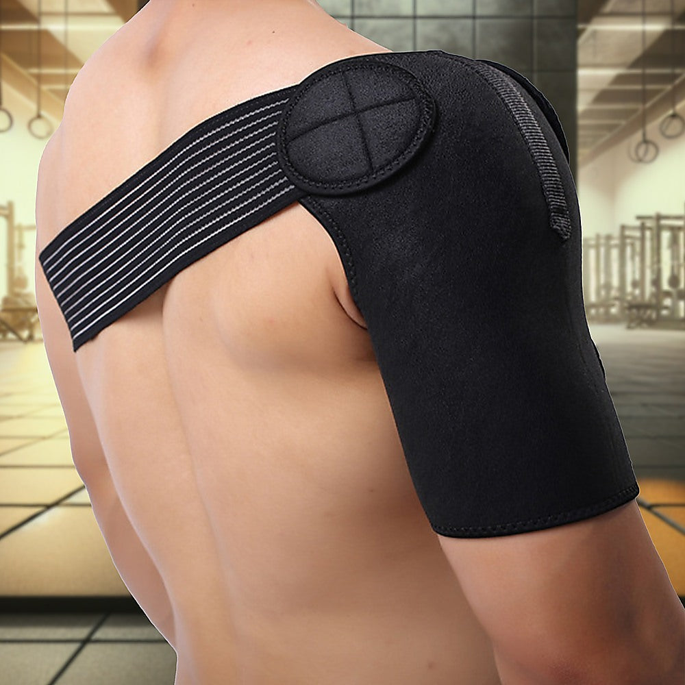 Black shoulder brace being worn on a person with a blurred indoor background