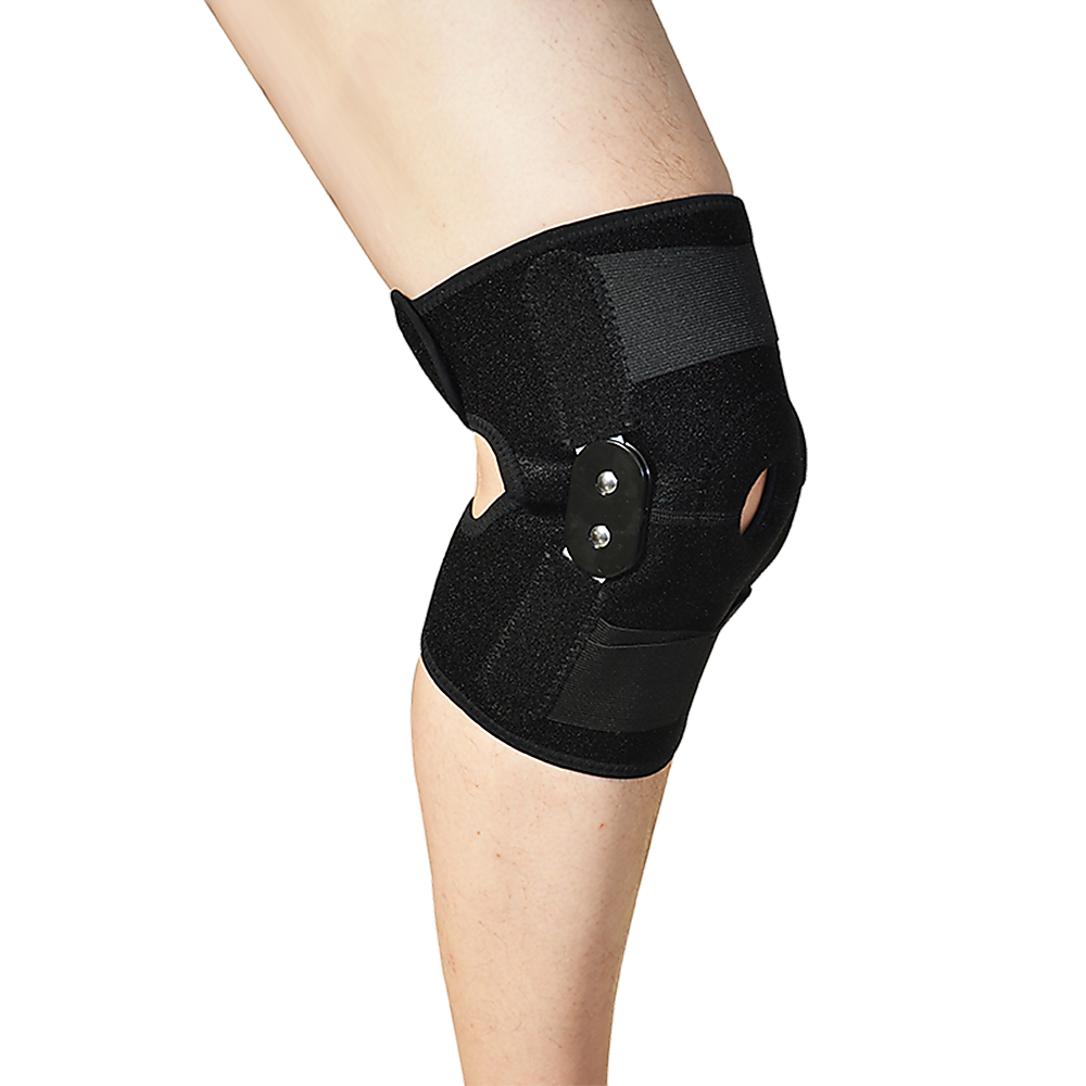 Black knee brace on a person's knee against a white background