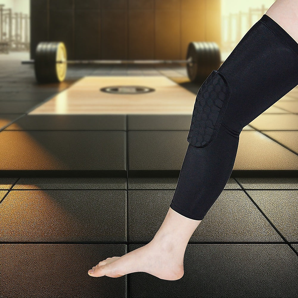 Person wearing a black knee pad in a gym setting with weights in the background