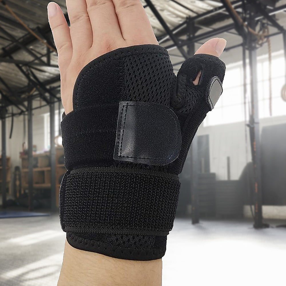 Black wrist support brace on a person's wrist in an indoor setting