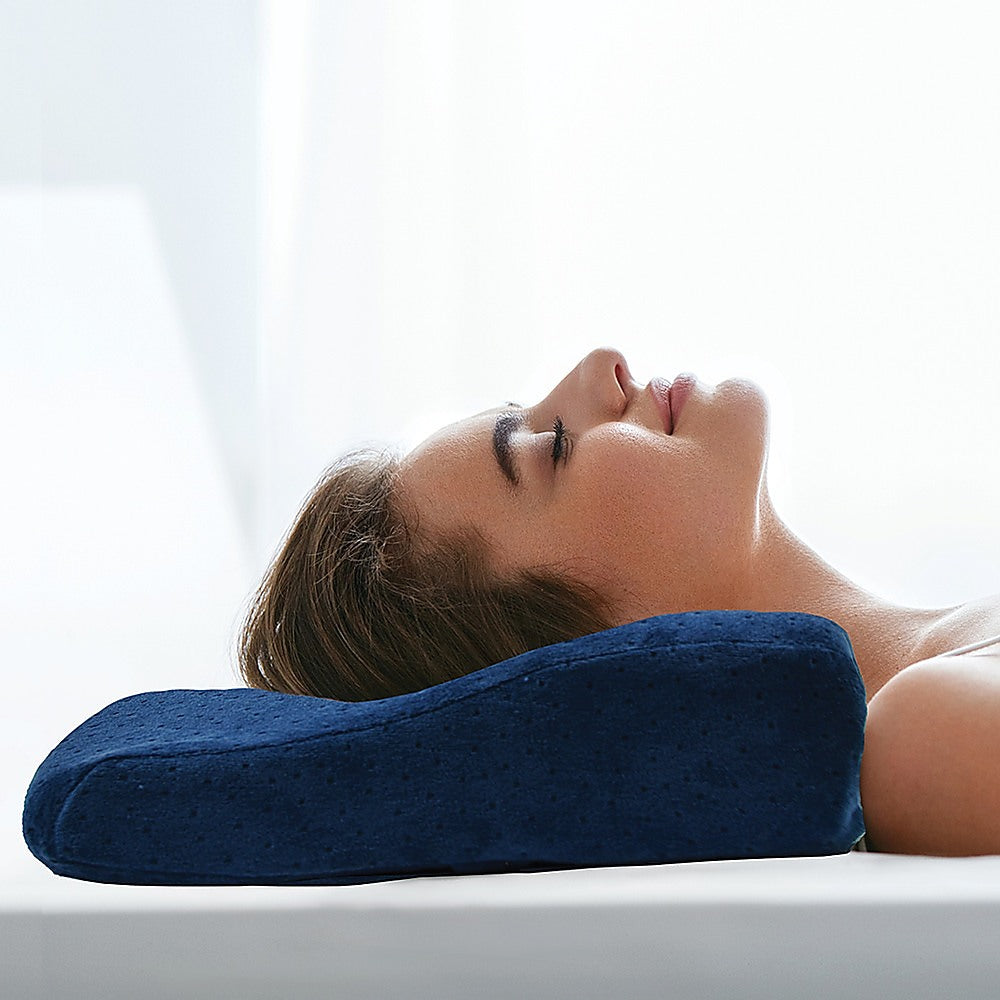 Woman using a blue neck pillow in a bright room