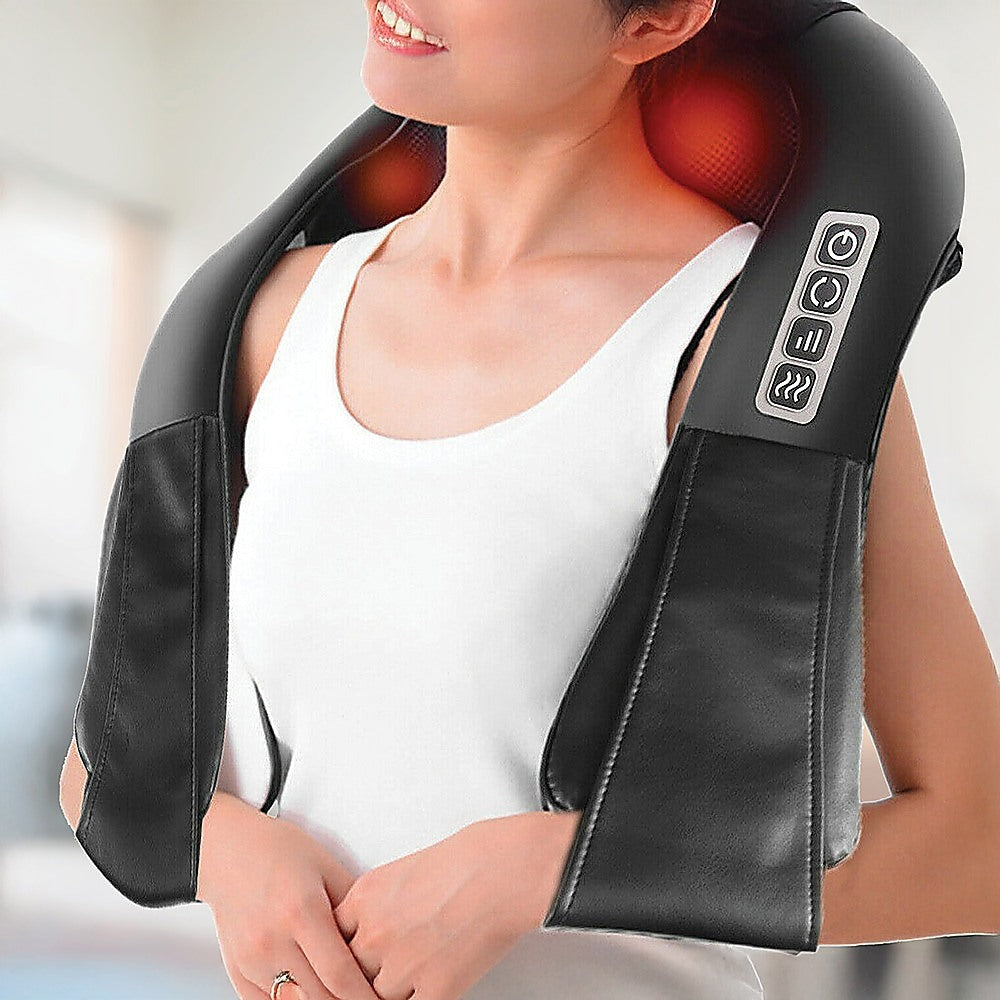 Person using a black neck and shoulder massager with a blurred background