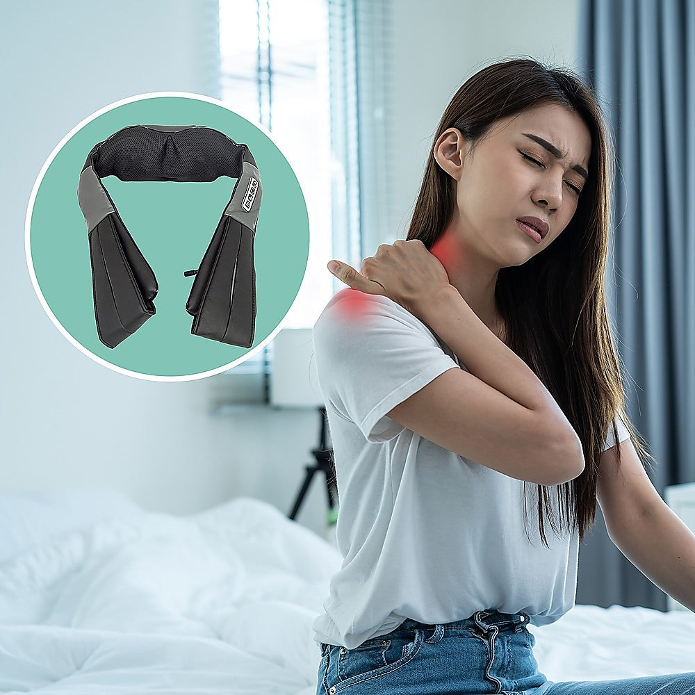 Woman with shoulder pain using a neck and shoulder massager.