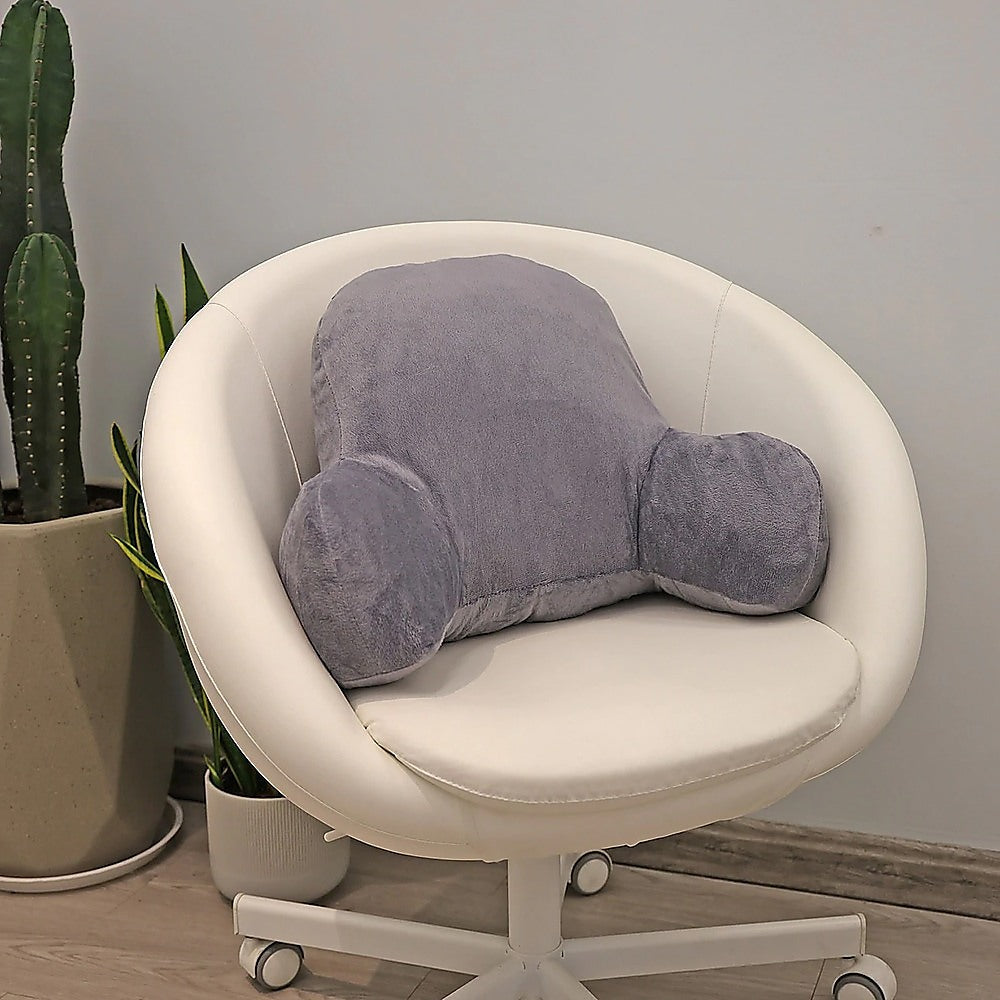 Gray backrest pillow on a white chair with plants in the background