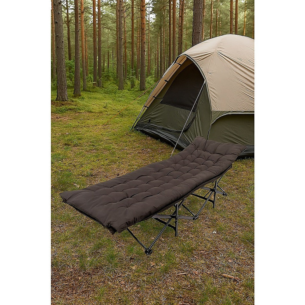 Camping cot in front of a tent in a forest setting
