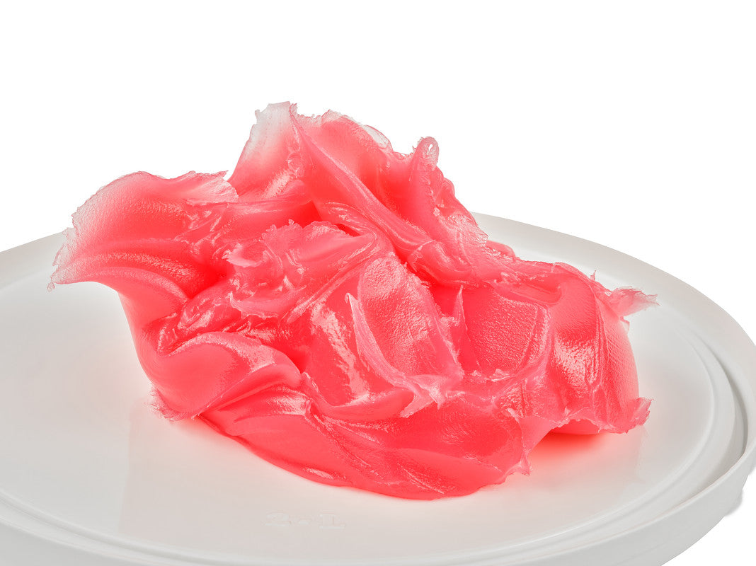 Pink gelatinous substance on a white plate with a white background
