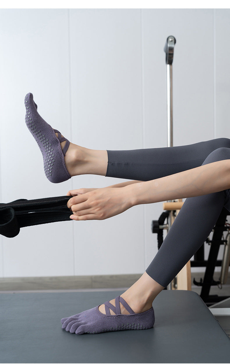 Person wearing purple socks with non-slip sole on a Pilates reformer machine.