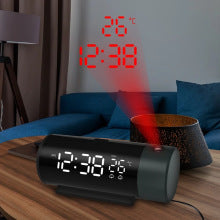 Digital clock with red light projection on a wooden surface