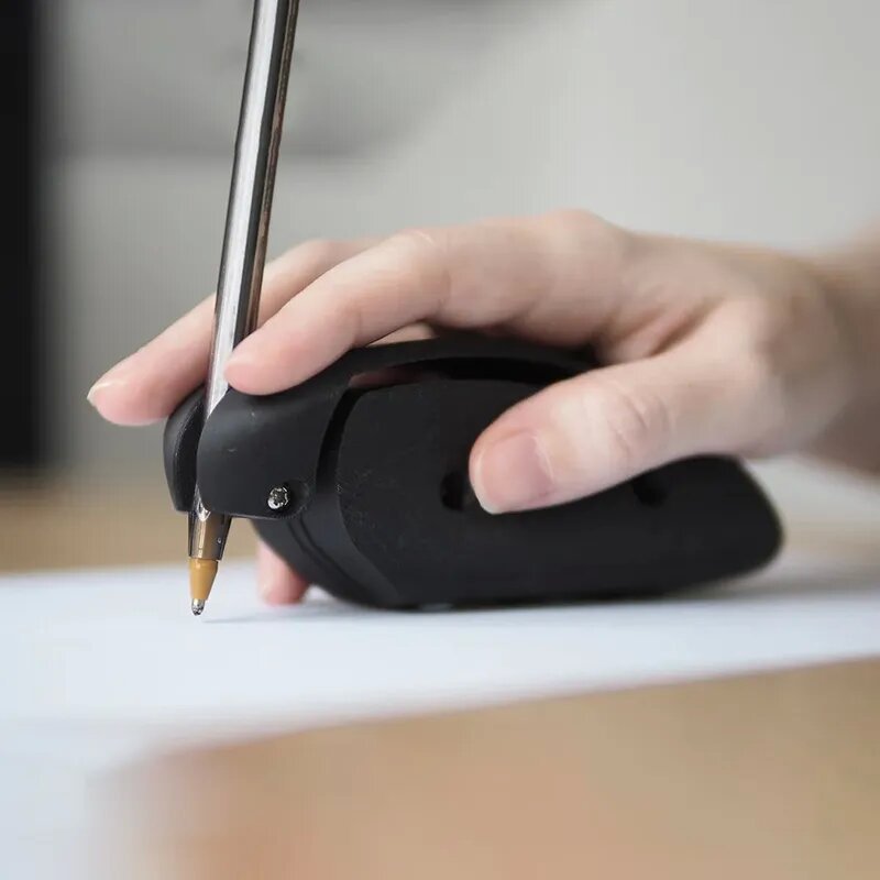 Hand using a black stapler on a white surface