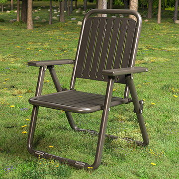 Brown folding chair on a grassy area with trees in the background