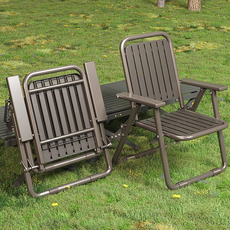 Two brown folding chairs on a grassy area