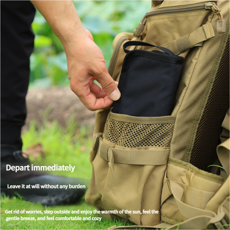 Person opening a beige backpack with a black item inside, outdoors.