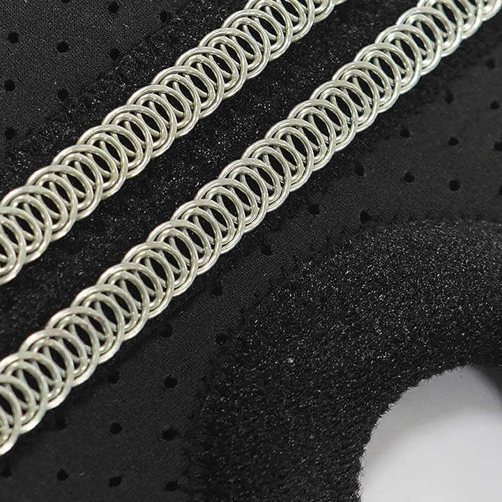 Close-up of metallic chainmail on a textured black surface