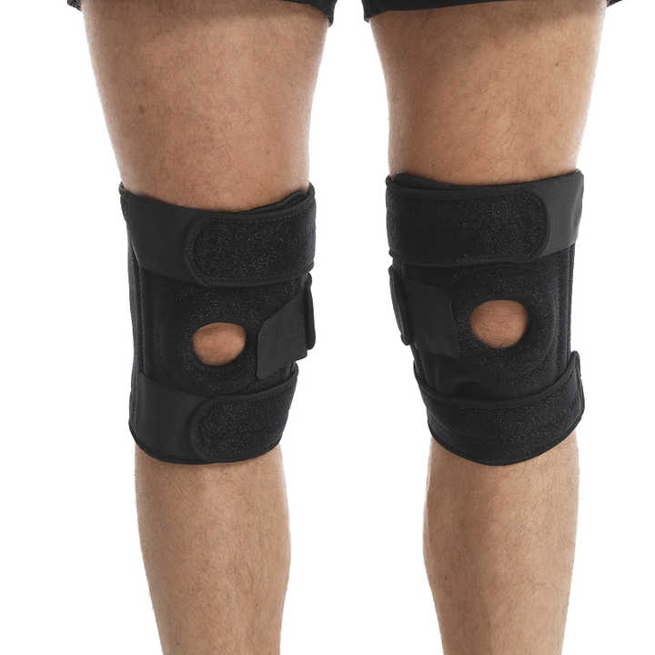 Black knee braces on a person's legs against a white background