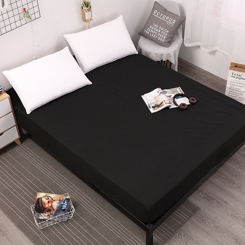 Black mattress cover on a bed with white pillows in a room setting.
