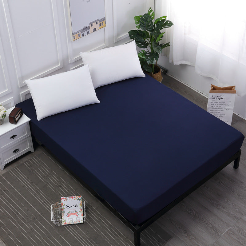 Navy blue mattress cover on a bed with white pillows in a room setting.