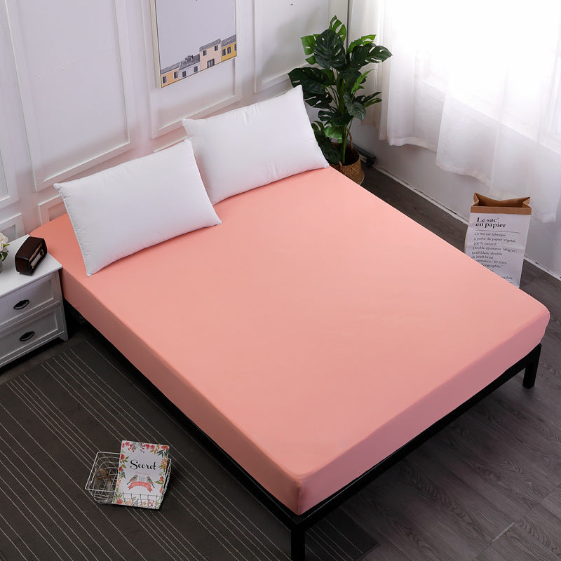 pink mattress cover on a bed with white pillows in a room setting.