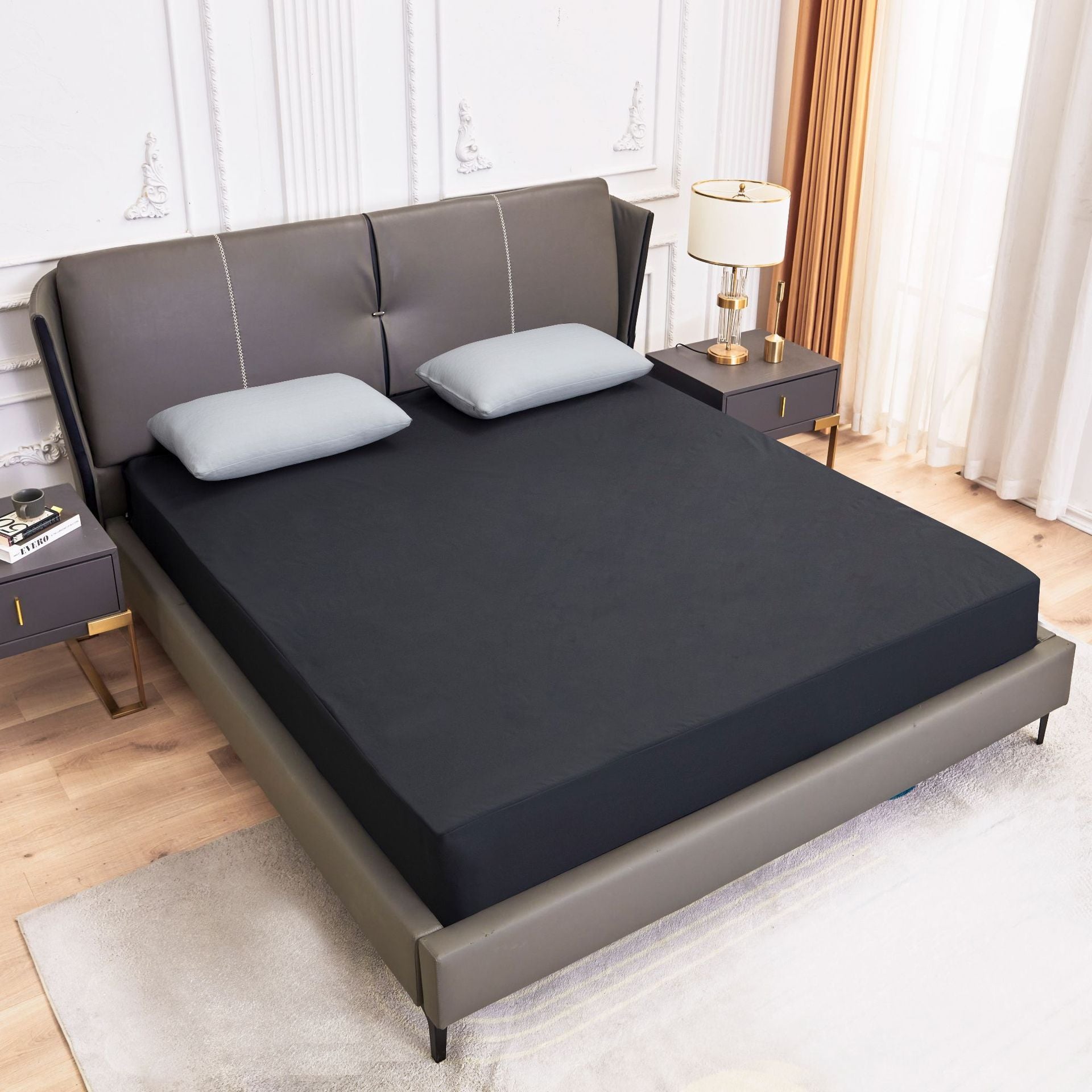 dark grey mattress cover on a bed with white pillows in a room setting.