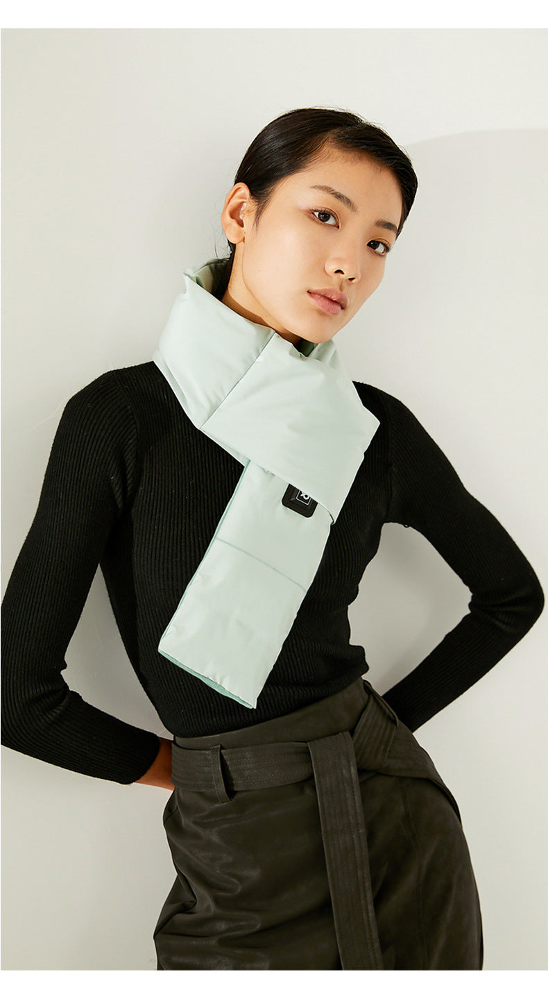 Person wearing a light green scarf with a black background