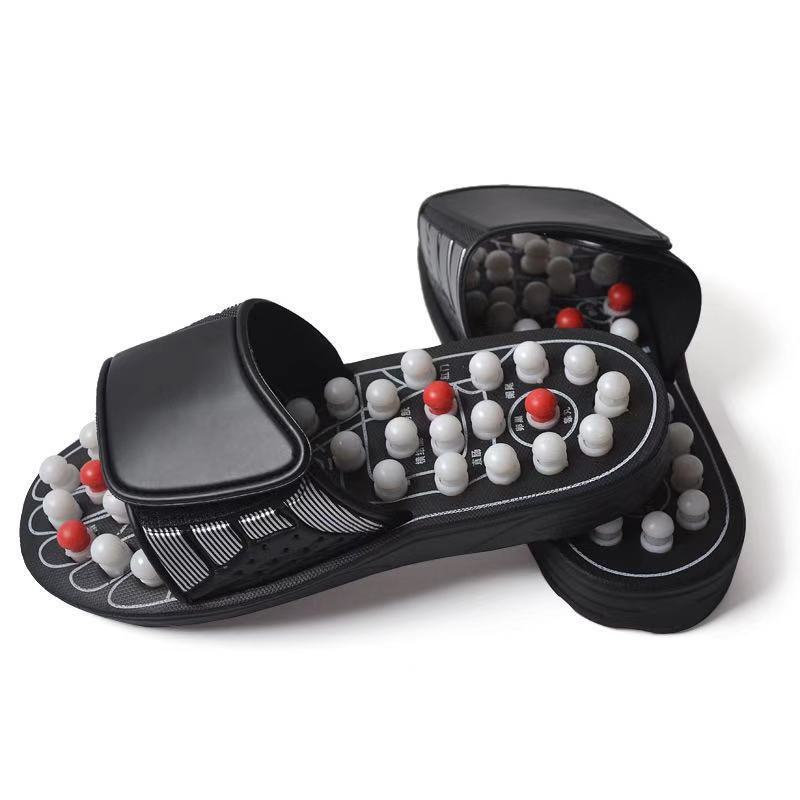 Pair of black massage sandals with nodes on a white background