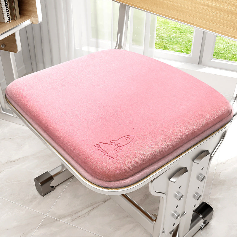Pink cushion on a chair with a visible brand logo in a room with a window.