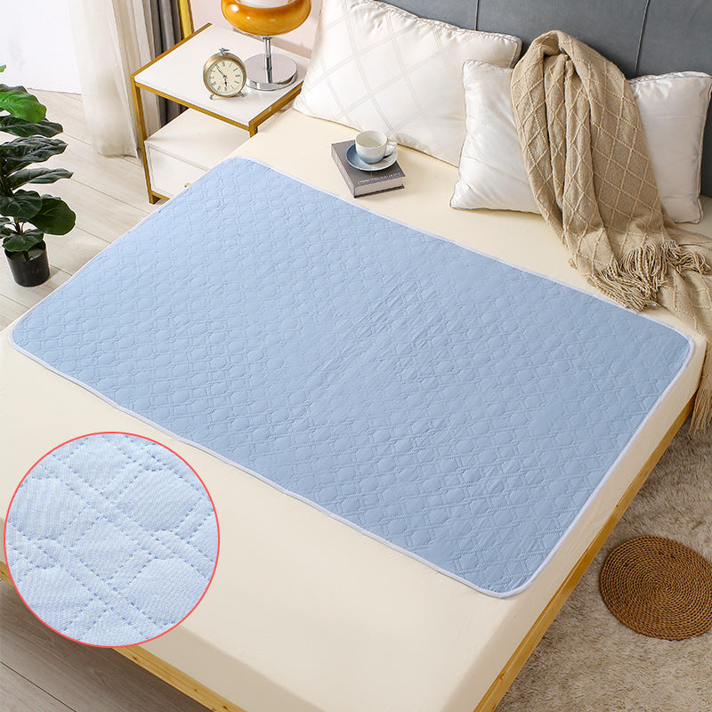 Blue quilted mattress pad on a bed with a close-up of the texture in the corner.