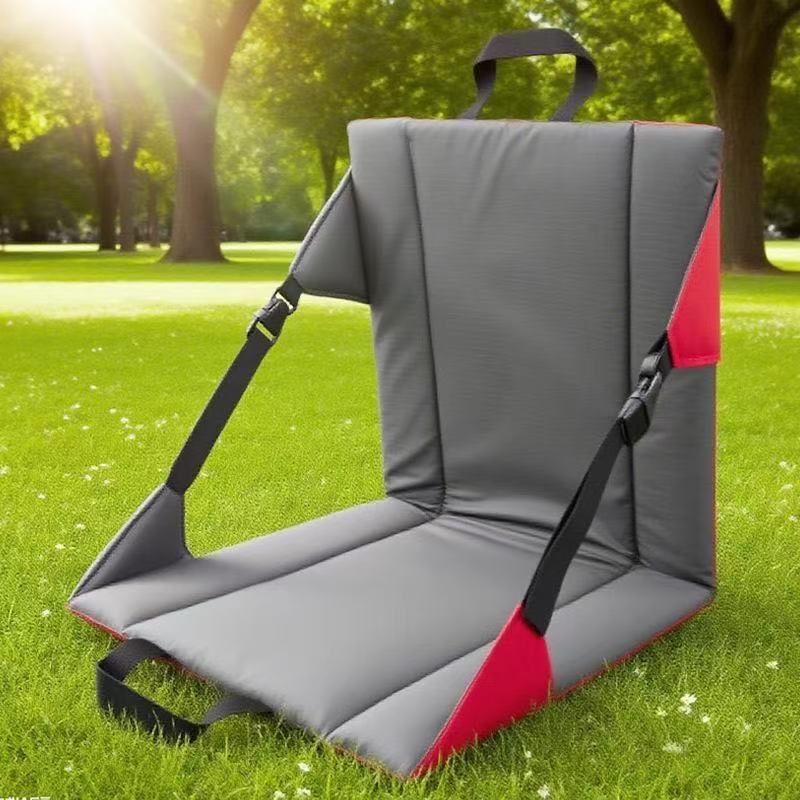 Gray and red outdoor seat垫on grass with trees in the background
