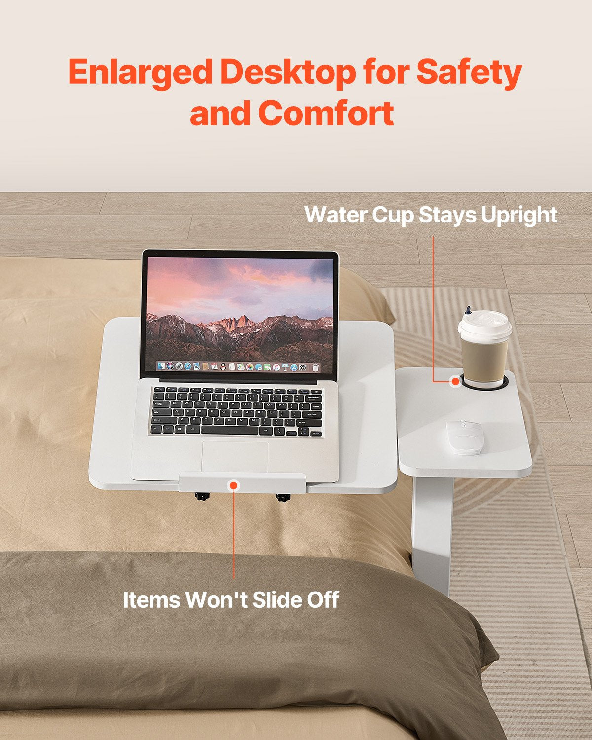 Laptop on an elevated desk with a water cup holder, placed on a bed.