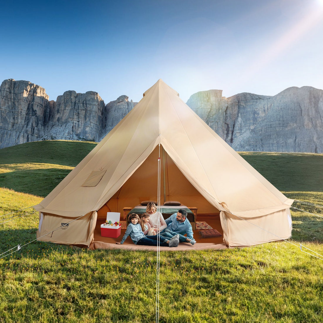 Beige tent with people sitting inside against a mountainous landscape