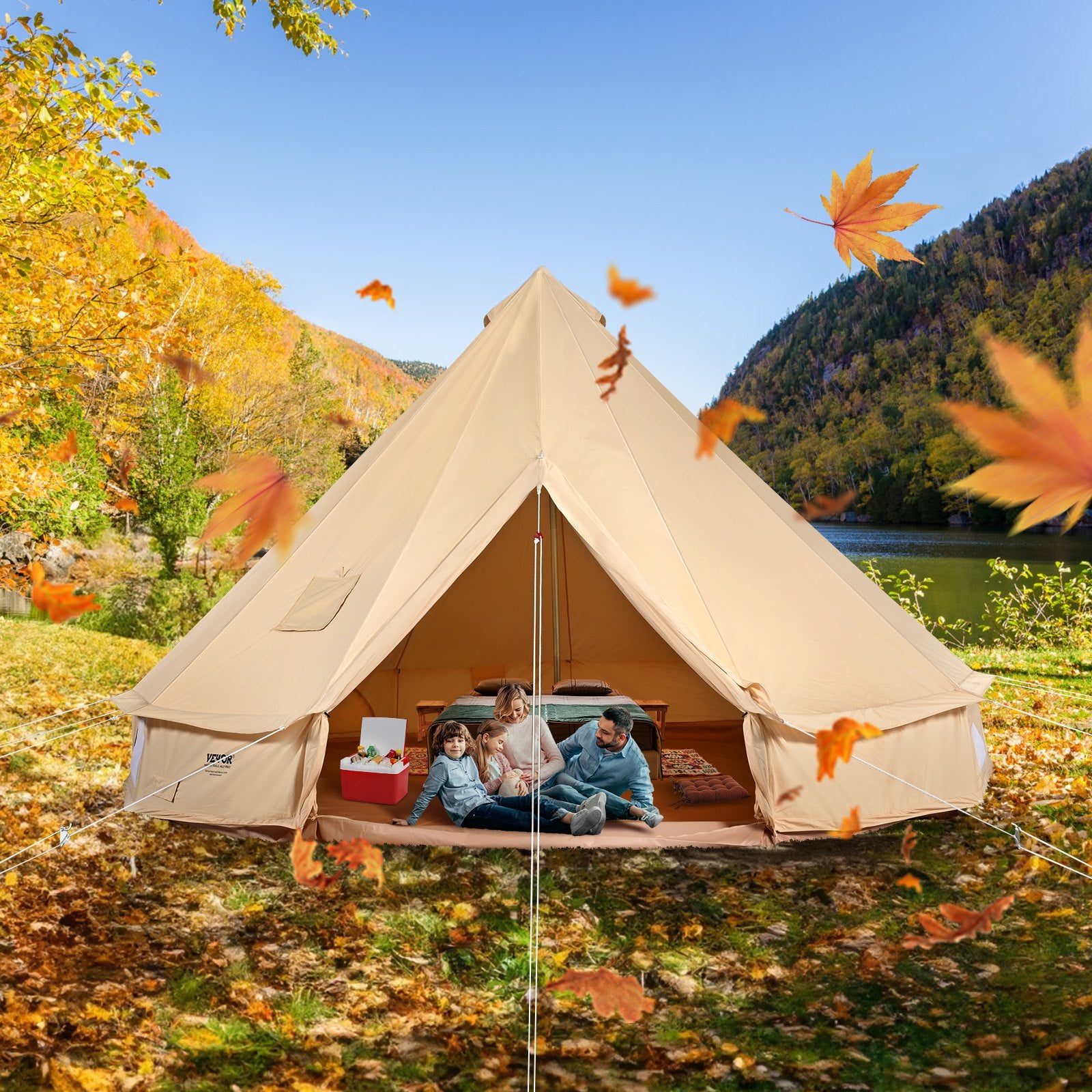 Beige bell tent in a scenic outdoor setting with mountains and trees, surrounded by autumn leaves.