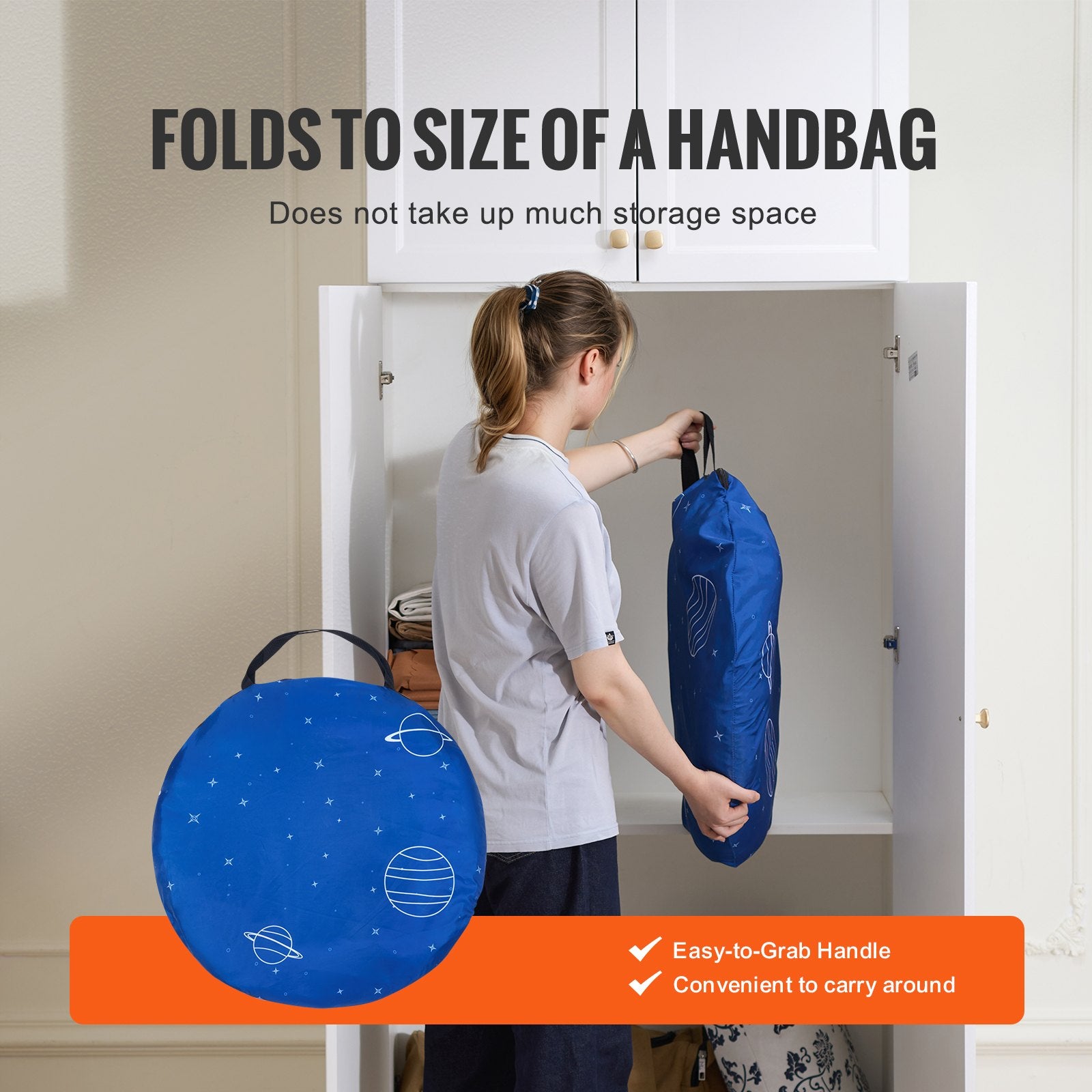 Person holding a blue bag with a handle, standing in front of a cabinet.